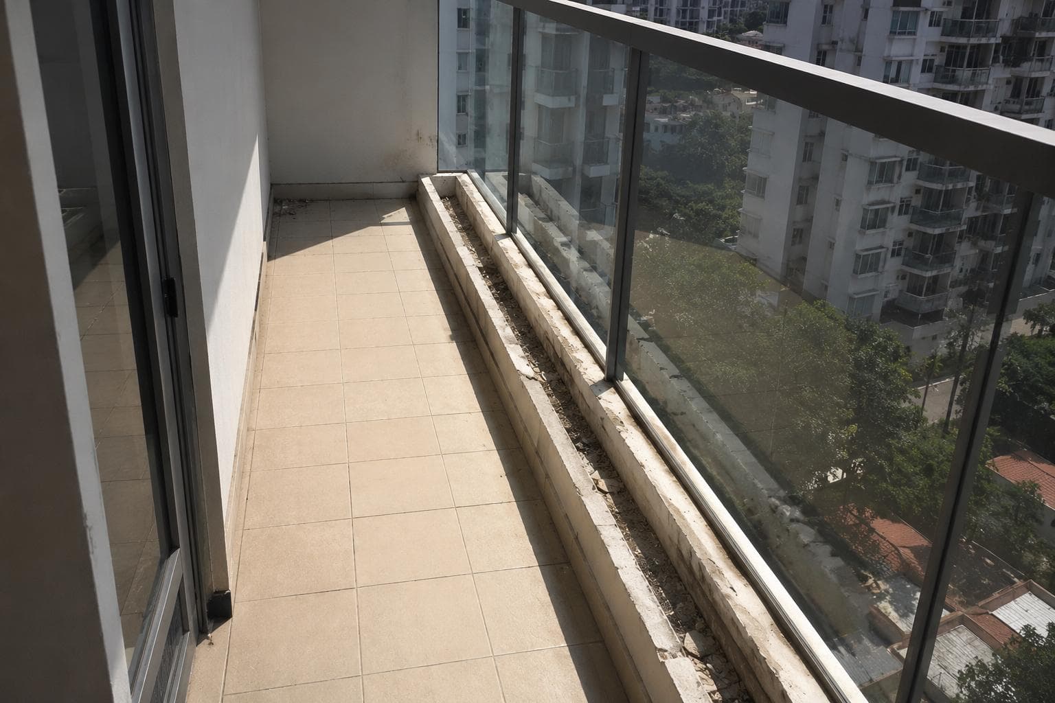 Narrow Singapore condo balcony before renovation with tiled floor and empty planter box